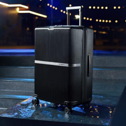 Single dark luggage on top of wet floor with reflections